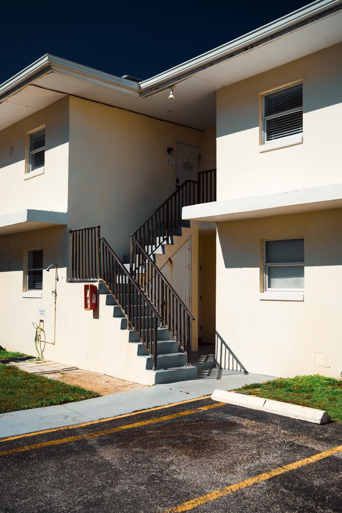 our-story A contemporary apartment building exterior featuring a stairway under bright sunlight.